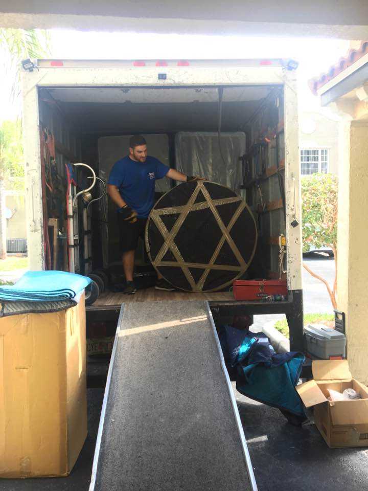 A man standing in the back of a moving truck.