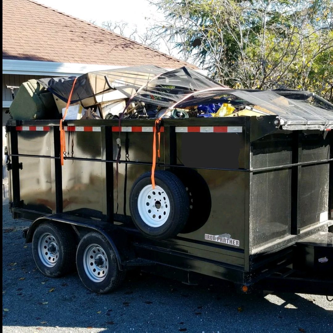 A dumpster with a trailer attached to it.