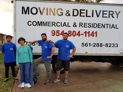 A group of people standing in front of a moving truck.