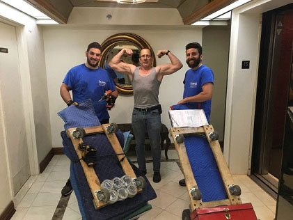 Three men in blue shirts and one man is flexing his muscles.