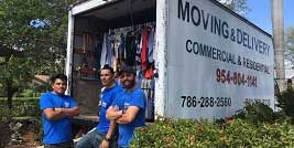 A group of men standing next to a moving truck.